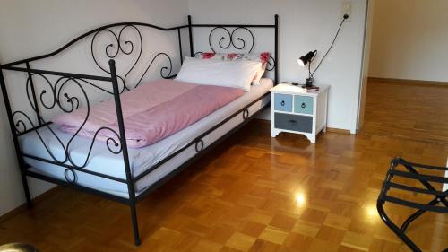 a bedroom with a bed with a metal frame and a table at Ferienwohnung Hagelstein in Bad Mergentheim