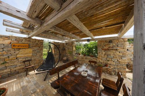 a room with a wooden table and a stone wall at Country House Olive Garden in Gorica
