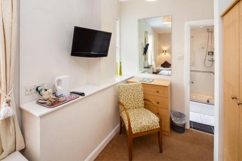 ヨークにあるAstor York Hostelのデスク、椅子、鏡が備わる客室です。