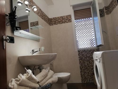 a bathroom with a sink and a toilet at Appartamento City in Palmi