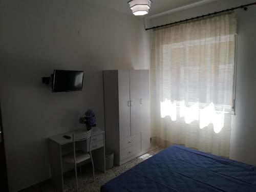 a bedroom with a bed and a desk and a tv at Appartamento City in Palmi