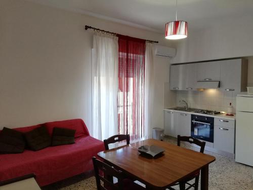 ein Wohnzimmer mit einem roten Sofa und einem Tisch in der Unterkunft Appartamento City in Palmi