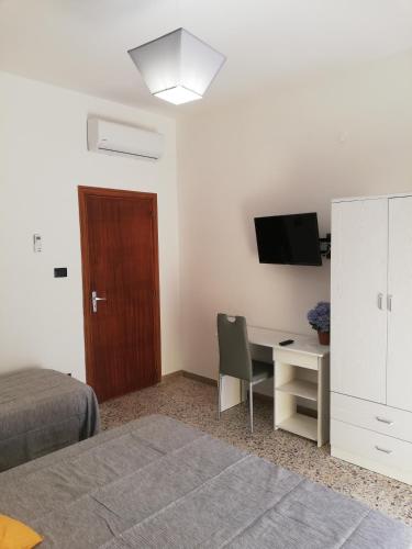 a bedroom with a bed and a desk and a tv at Appartamento City in Palmi