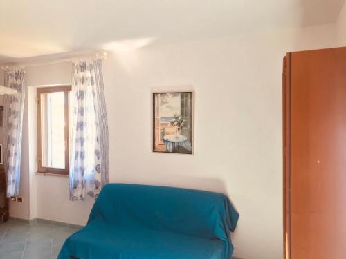 a room with a blue couch and a picture on the wall at Ponza Cala Feola IMMOBILEVANTE in Ponza