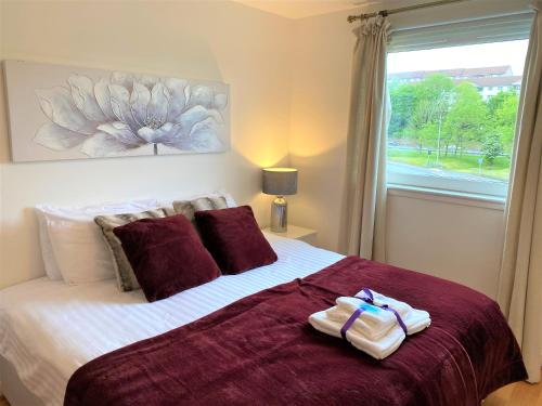 a bedroom with a large bed with towels on it at Firpark City Apartment - 2 Bedrooms in Glasgow