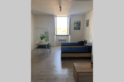 a living room with a bed and a table at La Fayette 2*, Meublé tout confort avec vue sur le port in Rochefort
