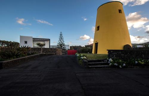 a yellow lighthouse on the side of a road at Wellshouses in Capelas