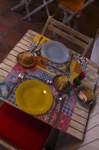 a table with a yellow plate on a table at Alter Ego b&b Assisi in Assisi