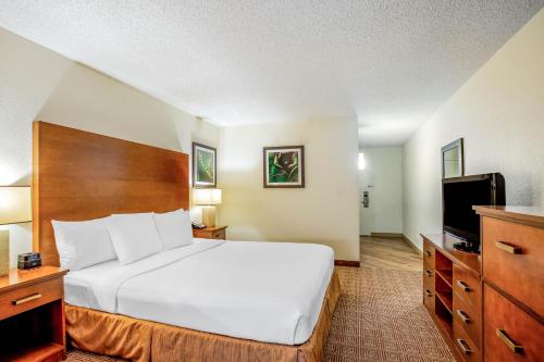 a hotel room with a bed and a flat screen tv at La Quinta by Wyndham Danbury in Danbury