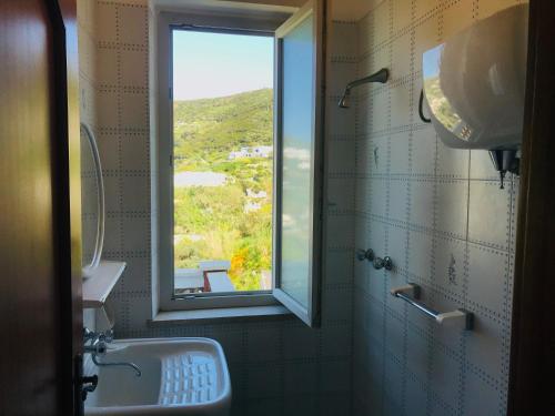 a bathroom with a sink and a window with a view at Ponza Cala Feola IMMOBILEVANTE in Ponza