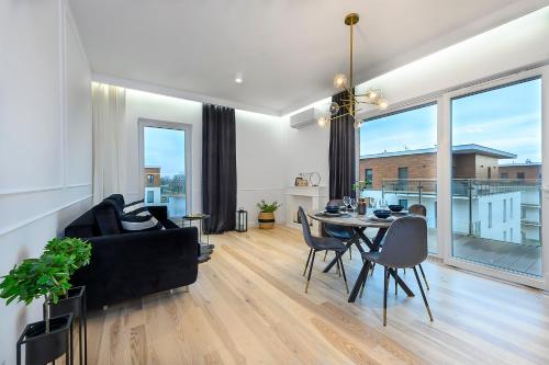 a living room with a table and a couch at Marina Glamour - 3pok, widok na jezioro, klimatyzacja, parking podziemny, winda, Netflix in Iława