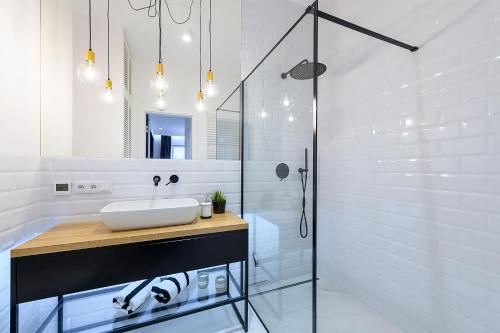 ein weißes Badezimmer mit einem Waschbecken und einem Spiegel in der Unterkunft Marina Glamour Apartment plus parking w hali in Iława