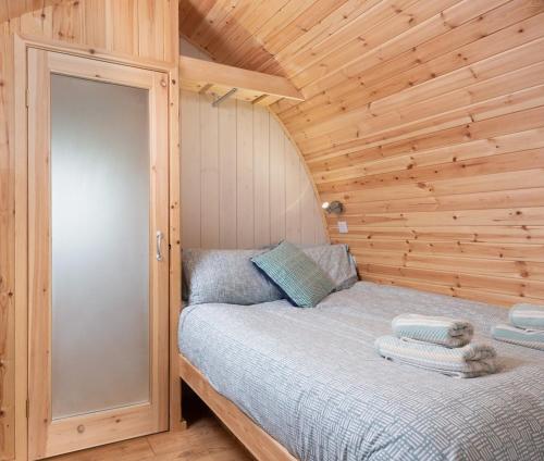 ein Schlafzimmer mit einem Bett in einer Holzhütte in der Unterkunft Low Greenlands Holiday Park - Luxury House & Luxury Glamping Pods in Lancaster