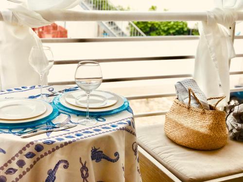 uma mesa com uma toalha de mesa com copos de vinho e uma bolsa em Sweet & cosy room next to the beach em Viareggio