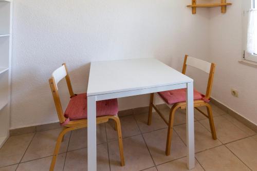 a table and two chairs with a white table at Apartments Kaktus Orebic in Orebić