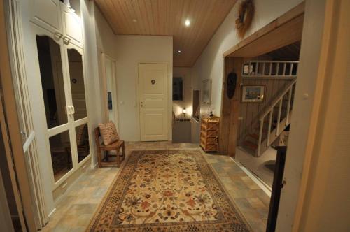 a hallway with a rug on the floor and a staircase at Villa Vimpasaari in Hamina