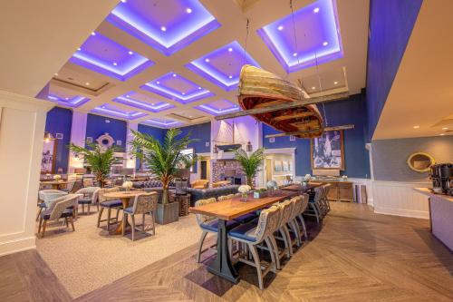 a restaurant with tables and chairs and a ceiling with blue lights at Hotel LBI in Ship Bottom