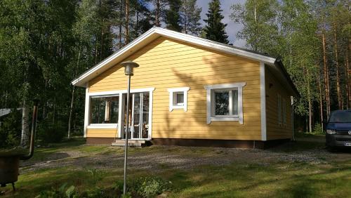 a small yellow house with a window in a yard at Kaijonselän mökit Pyhitty in Vehmaskylä