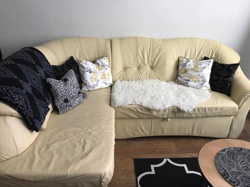a couch with pillows on it in a living room at Apartament w Domku in Gdynia
