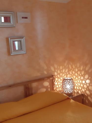 - une chambre avec un lit et une lampe sur un mur dans l'établissement La Casa di Ninna Affittacamere, à Ariano Irpino