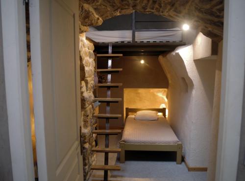 a small room with a bunk bed and a staircase at Le Paillier d'Etienne. in La Cresse