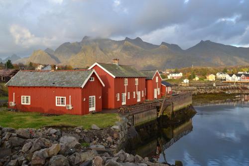 a group of red buildings next to a body of water at Statsbuene i Kabelvåg in Kabelvåg