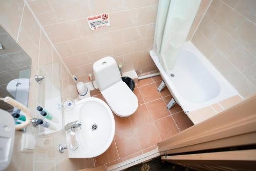 a bathroom with a sink and a toilet and a tub at SKYVersal in Astana