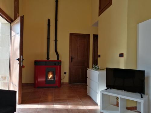 a living room with a fireplace and a tv at EL ATERPE in Aldehuela del Rincón