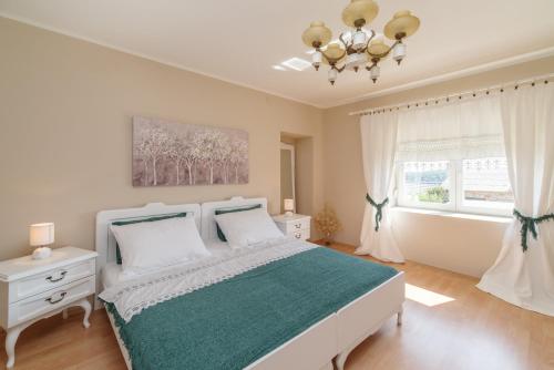 um quarto com uma cama branca e uma janela em Barac Rural Holiday Home em Grižane