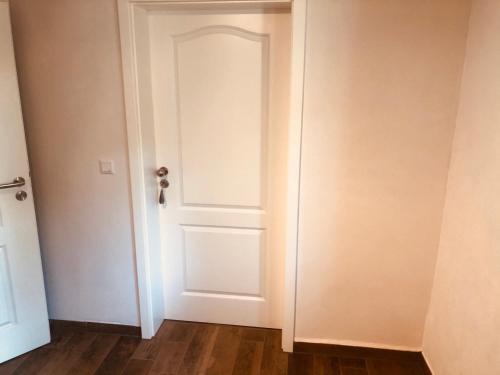 a white door in a room with a wooden floor at Ferienwohnungen Mey Haus zum Rosenstock in Erfurt