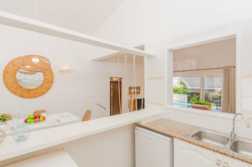 Una cocina blanca con fregadero y ventana. en Villa Noelia, en Santo Tomás