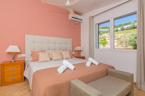 a bedroom with a bed with white pillows and a window at Villa Noelia in Santo Tomás