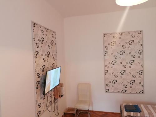 a room with a television and a painting on the wall at Kriston Apartman in Miskolc