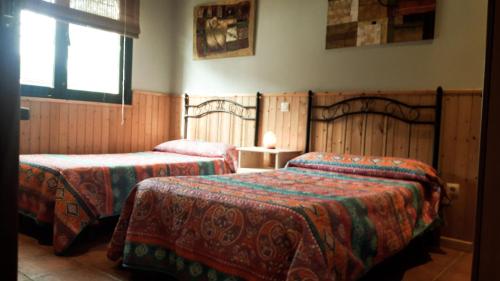 a hotel room with two beds and a window at La Casa de La Veleta Naturaleza y Calma in La Rinconada de Tajo