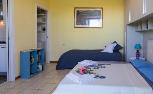 チヴィタノーヴァ・マルケにあるCasa "La Conchiglia"のベッドルーム1室(ベッド2台、花のテーブル付)