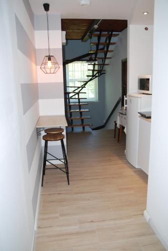 a hallway with a staircase and a table and stool at Willa Anna in Szczawno-Zdrój