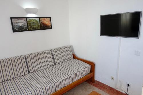 a living room with a couch and a flat screen tv at Oura Ocean Front in Albufeira