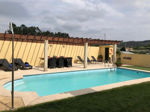 a swimming pool with a table and chairs next to a building at MR alheira house in Barcelos