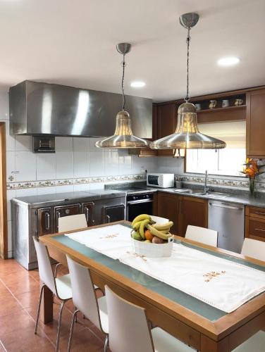 a kitchen with a table with a bowl of bananas on it at MR alheira house in Barcelos