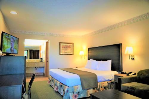 um quarto de hotel com uma cama e uma sala de estar em College Inn em Monmouth