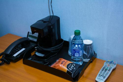 a coffee maker with a bottle of water and a remote control at At 9 Motel in Howell