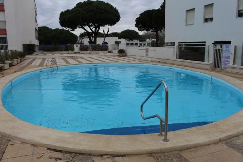 une grande piscine bleue devant un immeuble dans l'établissement LE CLUB - APPARTEMENT T3 Centre ville, à La Grande Motte