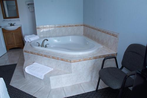a bath tub in a bathroom with two chairs at At 9 Motel in Howell