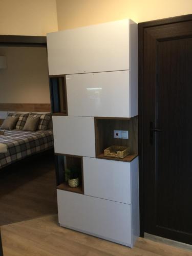 un alto comò bianco in una stanza con un letto di Your Place Apartment a Varna