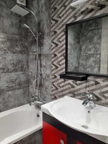 a bathroom with a sink and a tub and a mirror at villa Viktor in Truskavets