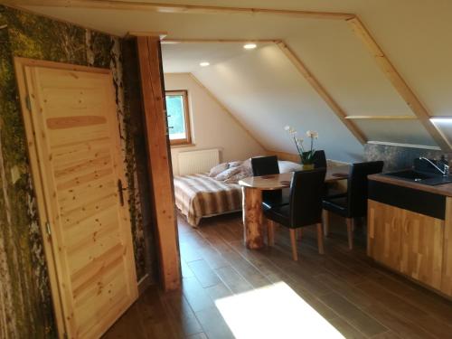 a room with a table and chairs and a bed at Apartmán Life in Nature in Jaronice