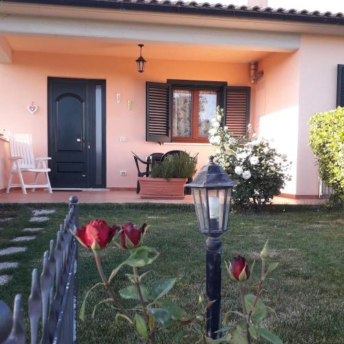 a house with a black door and a lamp at Residence Ai Campi Da Golf Saturnia in Saturnia