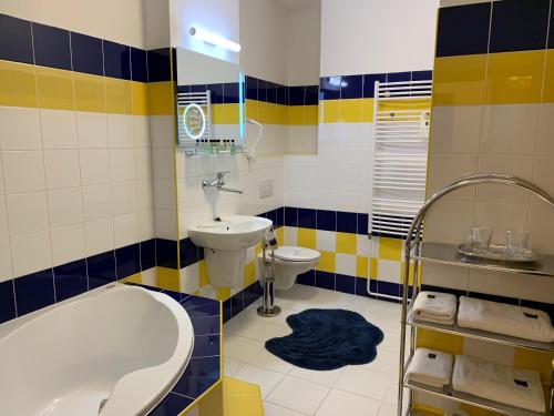 a bathroom with a tub and a sink and a toilet at Antik Hotel Sofia in Litomyšl