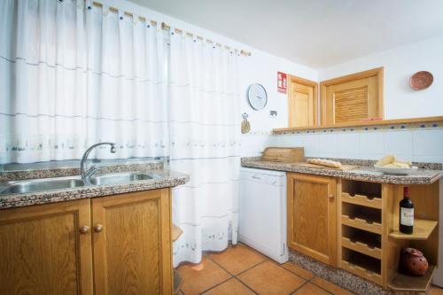 una cucina con lavandino e tenda per la doccia di Casa Amparo - Alquiler íntegro con encanto en Alicante ad Alcoleja