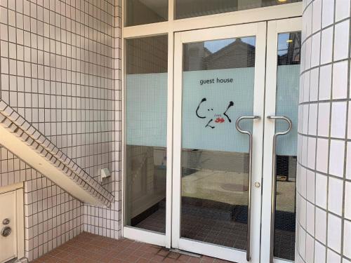 a glass door with a guest house sign on it at Sado - Hotel - Vacation STAY 82495 in Sado